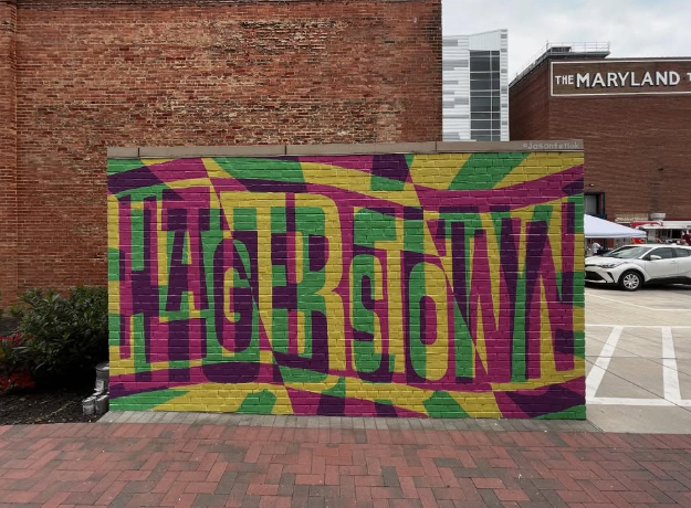 A colorful mural on a brick wall spells out 