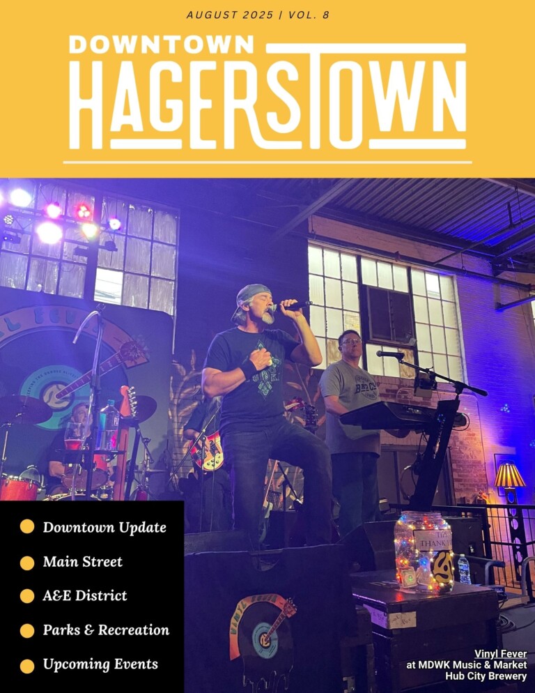 A band performs onstage under colorful lights at an indoor venue. The magazine cover reads 