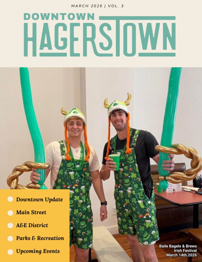 Two men dressed in St. Patrick’s Day-themed outfits and Viking hats hold large green balloon swords, smiling at an indoor event. Event details, magazine sections, and a newsletter sign-up are featured on the image.
