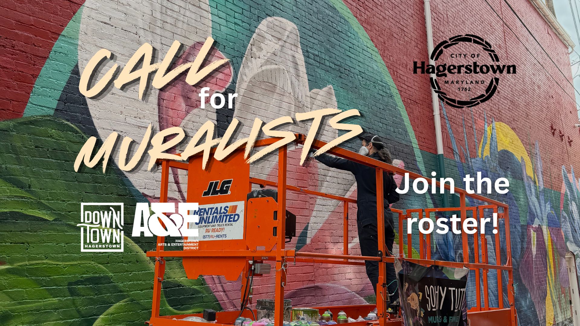 A mural artist works on a colorful brick wall from an orange lift. Text reads 