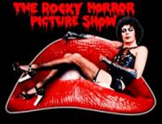 A person in black lingerie and heels reclines on large red lips, with “The Rocky Horror Picture Show” written above in red, dripping letters on a black background.