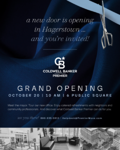 A scissors slices a blue ribbon above a Coldwell Banker Premier grand opening invite for a new Hagerstown office, with event details and small black-and-white photos of the downtown and office below.