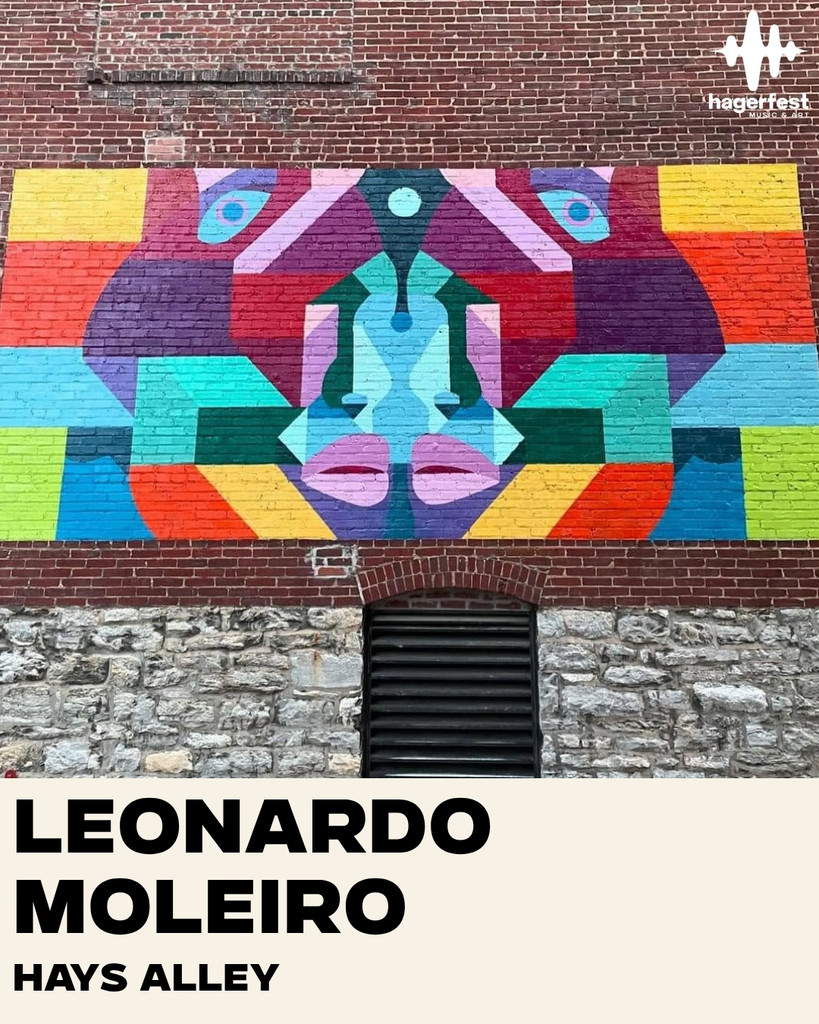 A colorful geometric mural on a brick wall above a vent, with text below reading “LEONARDO MOLEIRO HAYS ALLEY.” The top right corner has the “hagerfest” logo.