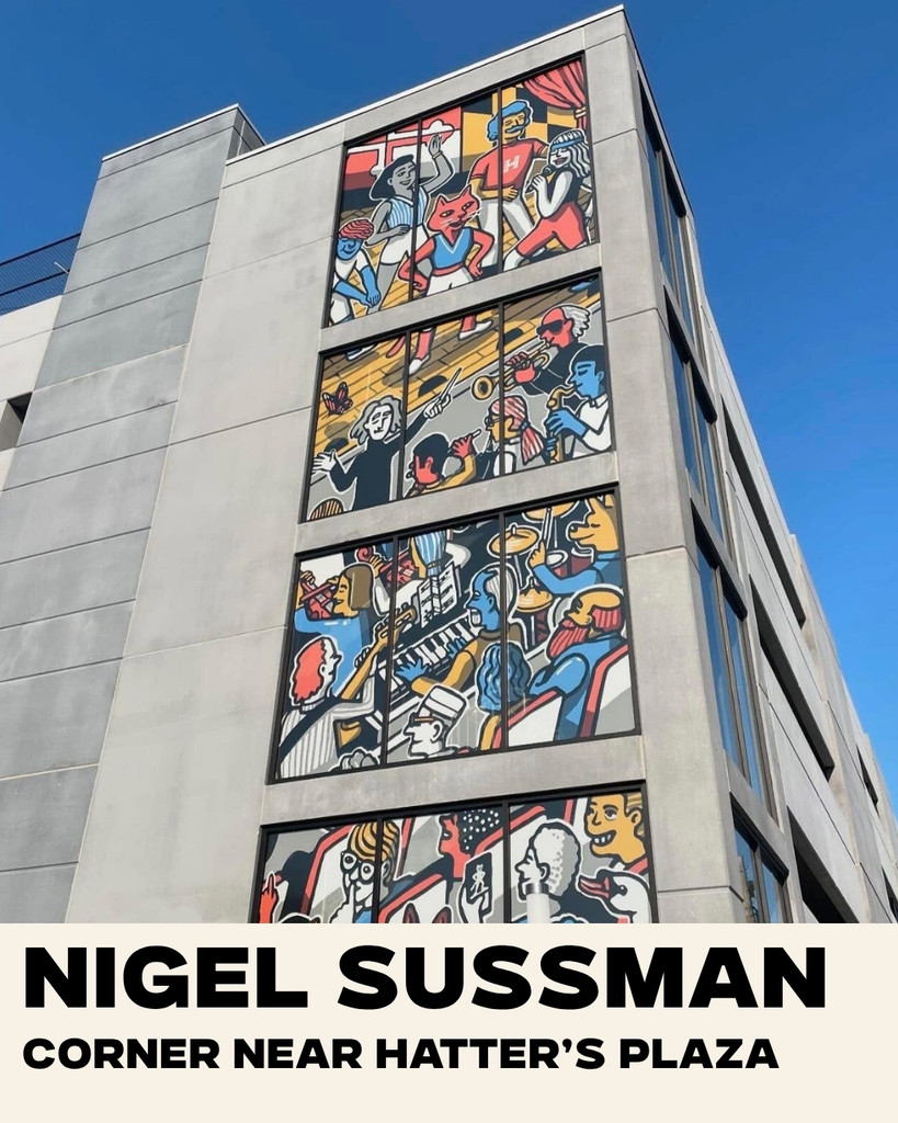 A modern building features a vibrant, multi-paneled mural with cartoon-like figures and musical elements. Text reads: “NIGEL SUSSMAN, CORNER NEAR HATTER’S PLAZA.”.